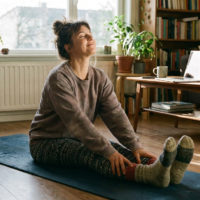 Mulher alongando na sala de estar com luz natural, representando treino em casa realista sem equipamentos.
